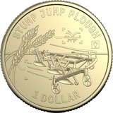 A gold-colored commemorative coin featuring an engraved stump jump plough and wheat stalk, with the text 'STUMP JUMP PLOUGH' and '1 DOLLAR' on a plain white background.
